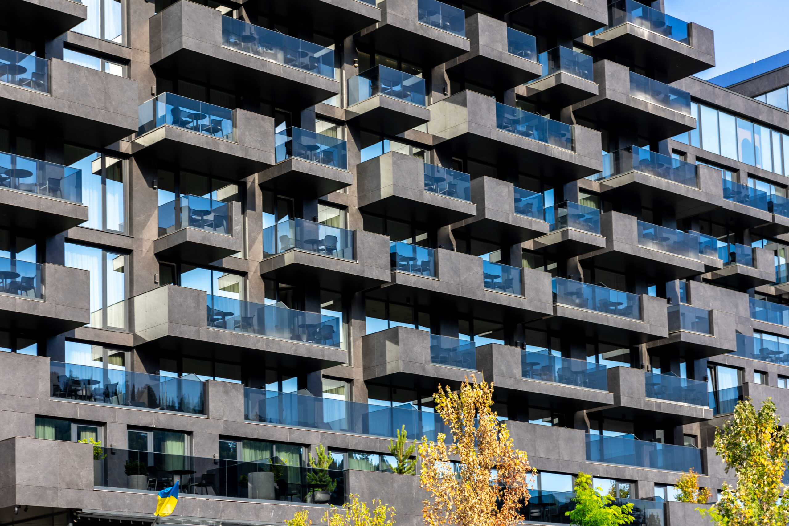 Balkonų renovacijos darbų eiga Kai visi leidimai ir dokumentai sutvarkyti, galima pereiti prie praktinės dalies – balkono atnaujinimo darbų. Šis procesas paprastai vyksta keliais etapais ir reikalauja profesionalumo, ypač jei konstrukcija pažeista ar silpna. Nors smulkius paviršiaus atnaujinimus galima atlikti savarankiškai, rimtesniems darbams būtina samdyti sertifikuotus specialistus. Balkono būklės įvertinimas ir techninė apžiūra Pirmasis žingsnis – esamos būklės įvertinimas. Meistras ar inžinierius patikrina, ar betonas nepažeistas, armatūra nerūdija, o laikantieji elementai vis dar stabilūs. Šis etapas yra būtinas, nes paviršiaus defektai gali slėpti gilesnes konstrukcines problemas. Jei nustatoma, kad plokštė deformuota ar įtrūkusi, rekomenduojamas kapitalinis remontas arba konstrukcijos keitimas. Projekto rengimas ir darbų planavimas Jei darbai reikalauja konstrukcinių pakeitimų, rengiamas techninis projektas, kuriame numatomi naudojami sprendimai, medžiagos ir darbų eiliškumas. Projektą turi parengti atestuotas konstruktorius, o darbų grafiką – statybos vadovas. Šiame etape taip pat apskaičiuojamos sąnaudos ir numatomi saugumo reikalavimai. Konstrukcijų stiprinimas arba keitimas Svarbiausia renovacijos dalis – laikančiųjų elementų stiprinimas. Tai gali būti betono plokštės sutvirtinimas nauju armavimo tinklu, pažeistų sijų pakeitimas ar tvirtinimo mazgų perprojektavimas. Kai kuriais atvejais senas balkonas visiškai demontuojamas ir įrengiamas naujas, laikantis šiuolaikinių statybos normų. Apdailos ir hidroizoliacijos darbai Atnaujinus konstrukciją, atliekami apdailos darbai: įrengiama nauja grindų danga (plytelės ar betono paviršius), sumontuojami turėklai ir atnaujinamas tinkas. Vienas svarbiausių žingsnių šiame etape – hidroizoliacijos sluoksnio įrengimas, kuris apsaugo betoną ir armatūrą nuo drėgmės bei užšalimo. Nuo hidroizoliacijos kokybės priklauso balkono ilgaamžiškumas. Galutinis patikrinimas ir priežiūra Po darbų atlikimo privaloma atlikti techninį patikrinimą – įvertinama konstrukcijos stabilumas, sandarumas ir atitikimas projektui. Savininkui pateikiamas darbų perdavimo aktas bei rekomendacijos dėl priežiūros: kada reikėtų atlikti apžiūras, kaip valyti ir prižiūrėti paviršius, kad balkonas tarnautų kuo ilgiau. Kaip pabrėžia vokiečių statybos ekspertas Ulrich Bauer, „Balkono renovacija nėra vien kosmetinis remontas. Tai konstrukcinė intervencija, kurios kokybė lemia ne tik estetiką, bet ir saugumą.“ Tinkamai atlikta renovacija leidžia balkonui tarnauti dar 20–30 metų, o jo priežiūra tampa minimali – svarbu tik periodiškai patikrinti sandarumą ir metalinių detalių būklę.